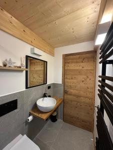 a bathroom with a sink and a wooden door at Maison ValGià in Champoluc +33 photos