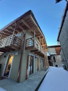a building with wooden balconies on the side of it at Maison ValGià in Champoluc