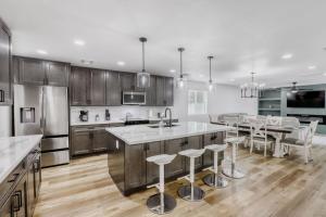 a kitchen with wooden cabinets and a kitchen island with bar stools at 4BR Mesa Basecamp, Mins to Cubs Spring Training in Mesa