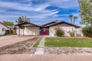 a house with a red door and a yard at 4BR Mesa Basecamp, Mins to Cubs Spring Training in Mesa