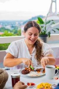 a woman sitting at a table with a plate of food at Hotel Posada Stella Maris in Puerto Barrios