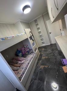 a small cabinet with stuffed animals in it in a kitchen at AP FRENTE MAR Compacto, Completo e Confortável in São Vicente
