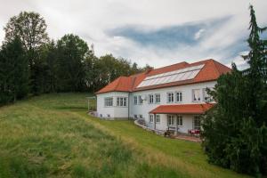 un grande edificio bianco con tetti rossi su una collina di Haus Steirer am Kaiserwald a Premstätten