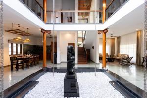 a dining room and living room with a statue in the middle at 1st Miracle By Mirth, Mythadi , Coorg in Ammatti