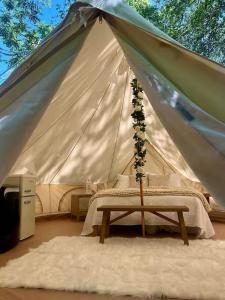 ein Schlafzimmer mit Bett in einem Zelt in der Unterkunft Rustic Ridge in Gentry