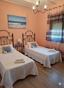 a bedroom with two beds with white sheets at El Burby II in Somo
