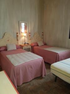 a room with two beds and a table with a lamp at Molino La Boticaria in Marchena