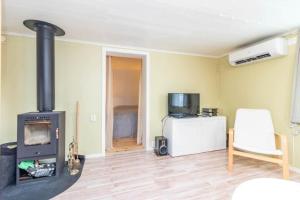 a living room with a wood stove and a chair at VAR986-Rada-As-34 in Råda