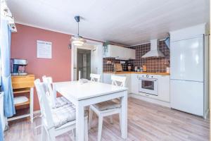 a kitchen with a white table and white chairs at VAR986-Rada-As-34 in Råda