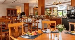 a restaurant with tables and chairs with food on them at Victor's Residenz-Hotel Berlin Mitte in Berlin