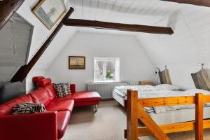 a attic bedroom with a bed and a red couch at AE315-Marstal-Kongensgade-8 in Marstal