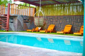 a group of chairs sitting next to a swimming pool at Makgadikgadi Riverview Inn in Nata