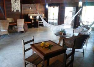 a living room with a hammock and a table and chairs at Casa Da MAELA in Corumbau