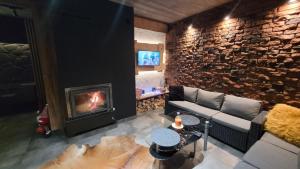 a living room with a couch and a fireplace at Cudodomek SPA Loft koło Ełku in Ełk
