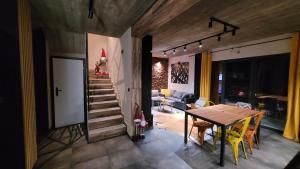 a room with a table and chairs and a staircase at Cudodomek SPA Loft koło Ełku in Ełk