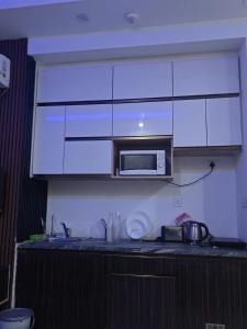 a kitchen with a counter top with a microwave at Aawas studio in Noida +12 photos