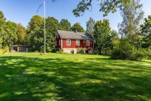a red house in the middle of a green field at BLE876-Holmsjoe-Husgoel-216 in Holmsjö