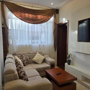 a living room with a couch and a large window at majesty beautiful suite in Cuenca