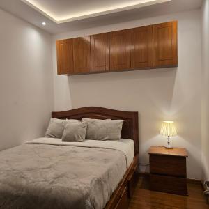 a bedroom with a bed and wooden cabinets at majesty beautiful suite in Cuenca