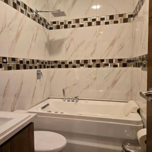 a bathroom with a tub and a toilet and a sink at majesty beautiful suite in Cuenca +10 photos