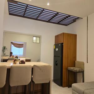 a kitchen with a table and a black refrigerator at majesty beautiful suite in Cuenca