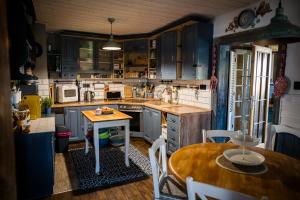 a kitchen with blue cabinets and a wooden table at Drevenička Modruška in Malý Čepčín +7 photos