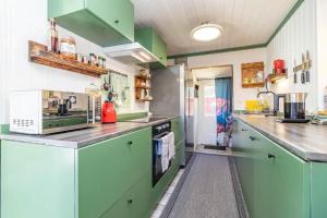 a large kitchen with green cabinets and appliances at BLE853-Holmsjoe-Aelmtamala-338 in Holmsjö