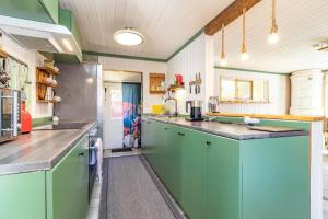 a large kitchen with green cabinets and counters at BLE853-Holmsjoe-Aelmtamala-338 in Holmsjö