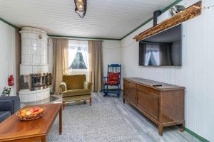 a living room with a couch and a table and a tv at BLE853-Holmsjoe-Aelmtamala-338 in Holmsjö +8 photos