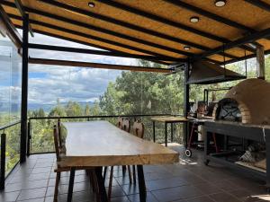 a wooden table on a balcony with a fireplace at Ziatá in Simijaca