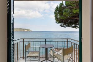a balcony with a table and chairs and the ocean at Hotel Arc En Ciel in Diano Marina
