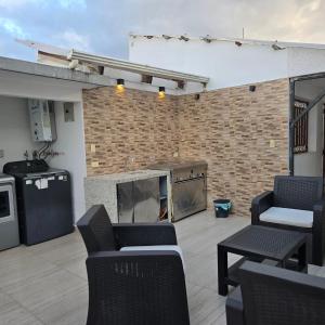 a patio with chairs and a fireplace and a brick wall at majesty beautiful suite in Cuenca