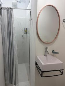 a bathroom with a sink and a mirror at Apartamento central próximo à catedral com 2 quartos e 2 banheiros in Santo Ângelo +10 photos