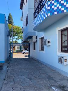 an alley between two buildings with blue and white at Apartamento central próximo à catedral com 2 quartos e 2 banheiros in Santo Ângelo