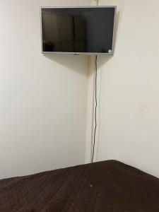 a flat screen tv hanging on a white wall at Apartamento central próximo à catedral com 2 quartos e 2 banheiros in Santo Ângelo