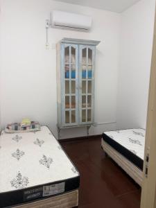 a room with two beds and a window in it at Apartamento central próximo à catedral com 2 quartos e 2 banheiros in Santo Ângelo
