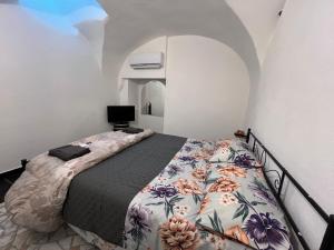 a bedroom with a bed with a floral blanket at La Dimora Della Volpe in Calice Ligure
