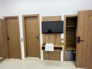 a room with three wooden doors with a television at Hotel kairouan in Fez
