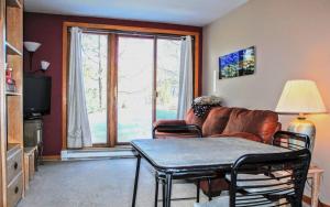 a living room with a couch and a window at Mountain Adventure Basecamp + Hot Tubs in Winter Park