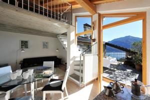 a small house with a balcony with a table and chairs at Belmonte Terrazzo in Pianello Del Lario