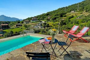 a patio with chairs and a table next to a pool at Belmonte Terrazzo in Pianello Del Lario
