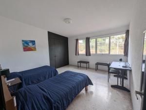a bedroom with two beds and a desk in it at Casa Amari - Para 17 Personas - Grupos y Eventos in Morelia