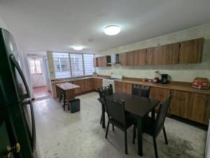 a kitchen with wooden cabinets and a table and chairs at Casa Amari - Para 17 Personas - Grupos y Eventos in Morelia