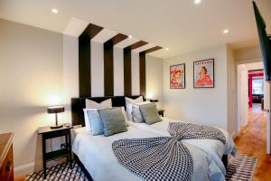 a bedroom with a large bed with blue pillows at The Simms Suite in Worthing
