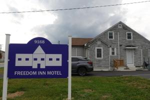 a sign in front of a house with a freedom inn motel at Freedom INN Motel in Grantville