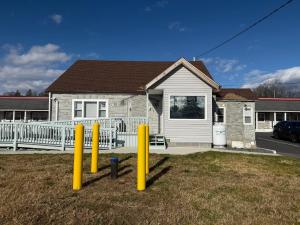 a house with yellow posts in the grass in front of it at Freedom INN Motel in Grantville