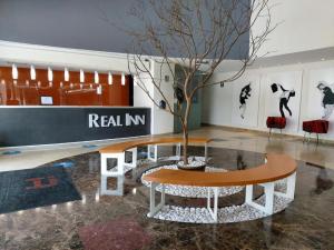 a table with a tree in the middle of a room at Real Inn Perinorte in Mexico City