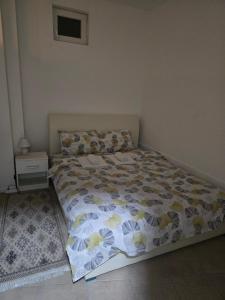 a bedroom with a bed with a bedspread with flowers at Iskra Apartment 2 in Kragujevac +4 photos