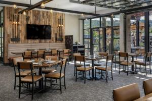 a dining room with tables and chairs and a flat screen tv at Sheraton Steamboat Resort Villas in Steamboat Springs