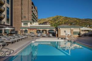 a swimming pool with lounge chairs and a building at Sheraton Steamboat Resort Villas in Steamboat Springs